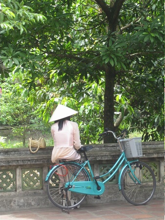 Vietnamese woman with bike. Tam Coc, Vietnam