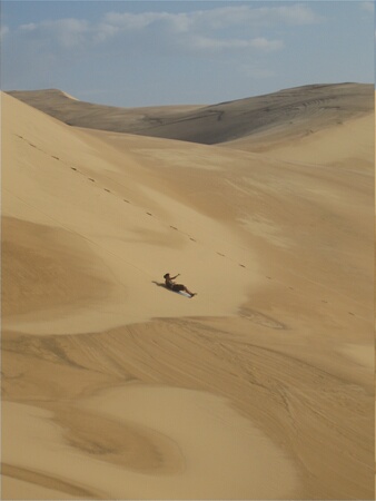 Cheryl sand sledging down a huge dune
